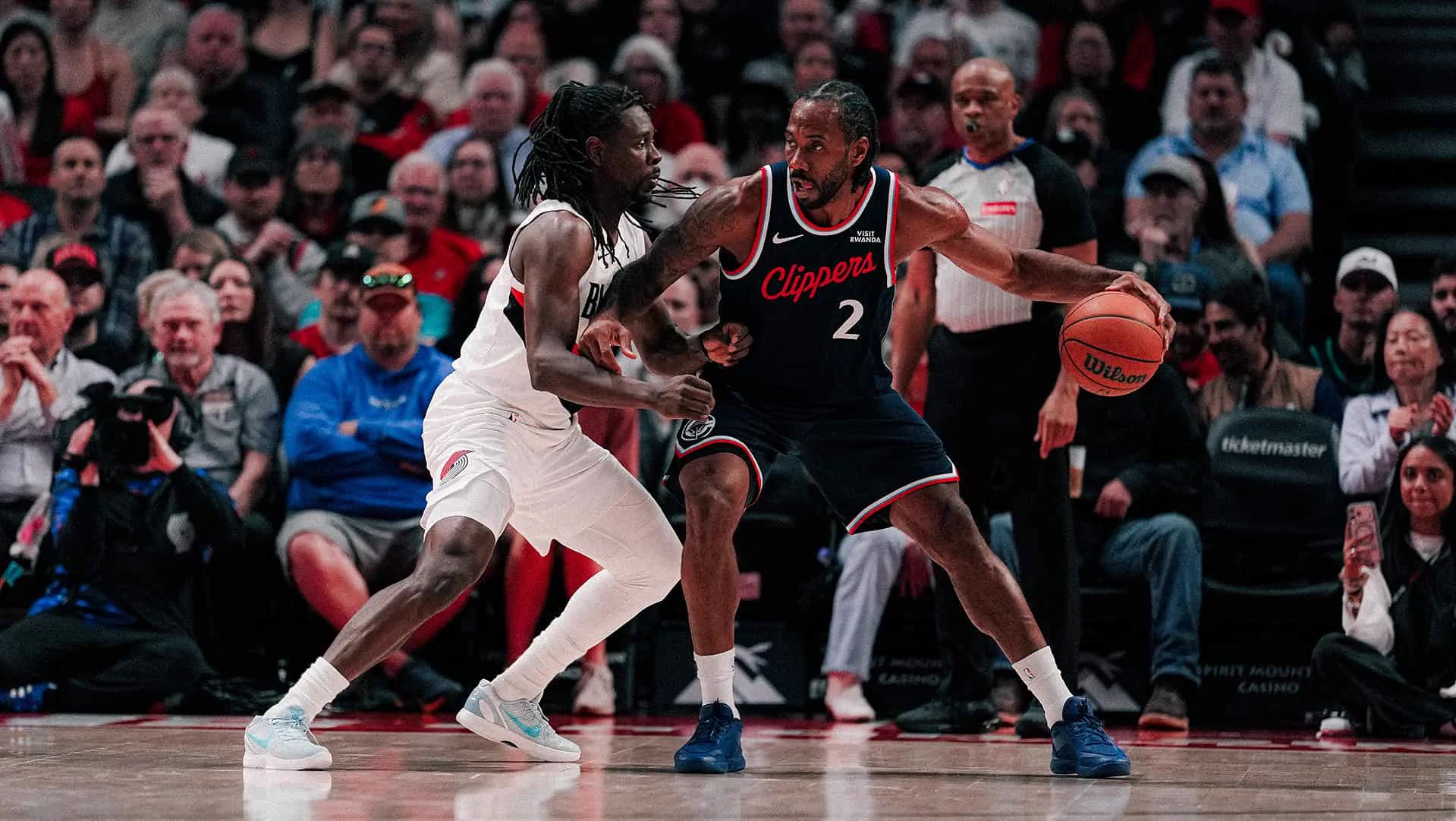 LA Clippers guard backing down a defender in front of a packed arena